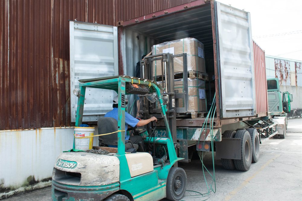 Forklift loading pallets into a container
